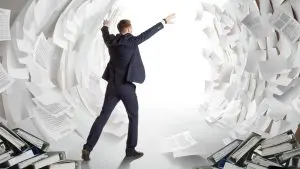 Businessman with documents flying all around him