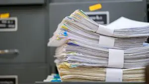 Stack of documents in front of file cabinets