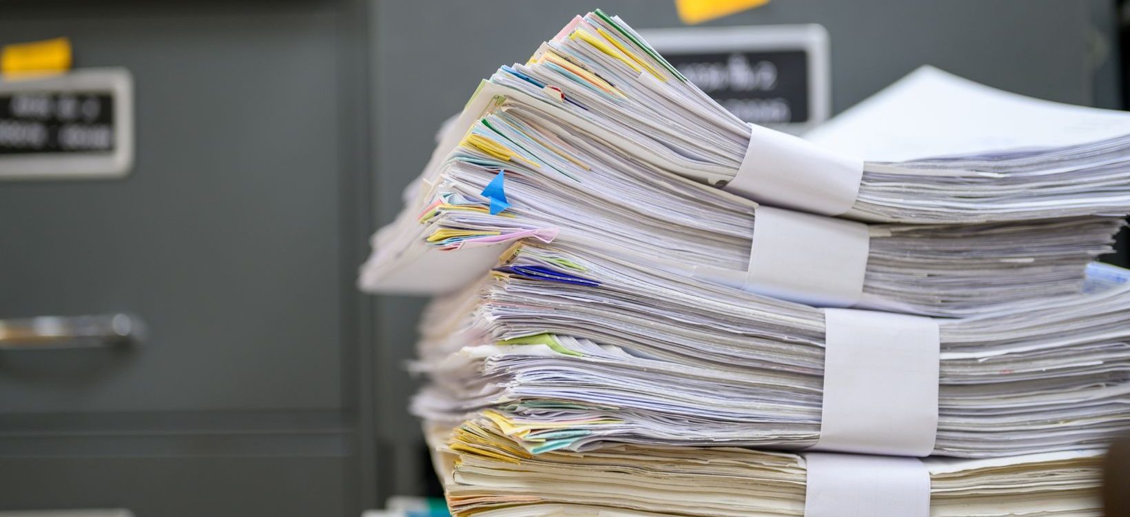 Stack of documents in front of file cabinets